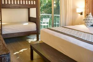 Zimmer im Sandos Caracol Eco Resort mit Doppelbett und Schlafbereich.