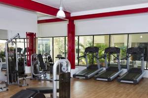 Fitness Center im Sandos Caracol Eco Resort mit Laufbändern und Kraftgeräten.