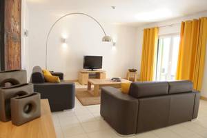 Wohnzimmer im Agua Hotels Sal Vila Verde mit zwei Sofas, Couchtisch und Fernseher.