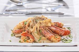 Gerecht aus Shrimps, Nudeln und Pilzen auf einem weißen Teller, serviert im Aeolos Beach Resort auf Korfu.