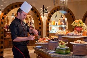 Koch des Ghazala Gardens Hotels bereitet Gerichte am Buffet zu