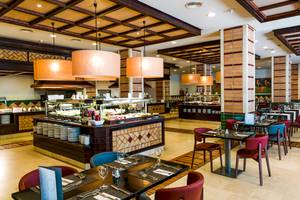 Innenansicht des Restaurants im H10 Estepona Palace mit Buffet und gedeckten Tischen.