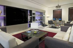 Modernes Wohnzimmer im H10 Estepona Palast mit großen Sofas, Tisch, Fernseher und Dekor.