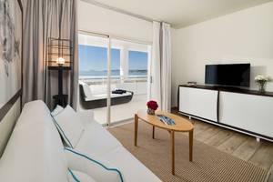 Wohnzimmer im H10 Estepona Palace mit Blick auf das Meer und eine Terrasse.