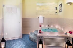 Badezimmer im H10 Estepona Palace mit Badewanne, beleuchtet und bereit für Entspannung.