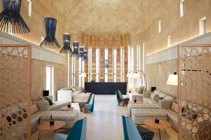 Lounge-Bereich im Domes Noruz Chania, Autograph Collection mit modernen Möbeln und Holzschirmlampen.