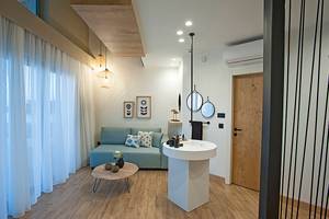 Innenbereich des Domes Noruz Chania, Autograph Collection mit Sofa, Tisch und Waschbecken.