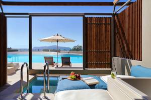 Suite mit Blick auf den Pool und Sonnenschirm im Domes Noruz Chania