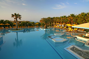 Außenpool des Porto Bello Beach Hotels mit Sonnenliegen und Palmen