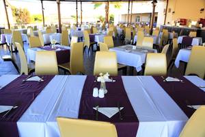 Ein Restaurant im LABRANDA Marine Aquapark mit vielen gedeckten Tischen und Stühlen.