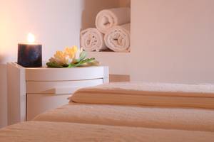 Spa-Bereich im LABRANDA Marine Aquapark mit einem Bett, einer Kerze und Blumen.