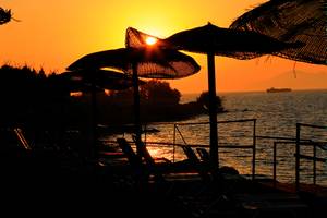 Abendstimmung am Strand des LABRANDA Marine Aquapark mit Sonnenuntergang und Sonnenschirmen.
