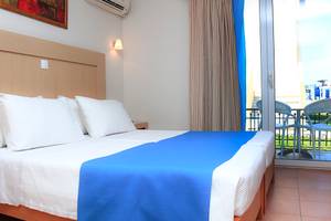 Foto eines Hotelzimmers im LABRANDA Marine Aquapark mit zwei Betten, weißen Kissen und einem Balkon.