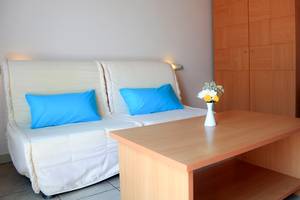 Foto von einem Hotelzimmer mit einem Sofa, einem Tisch und einem Blumenstrauß.