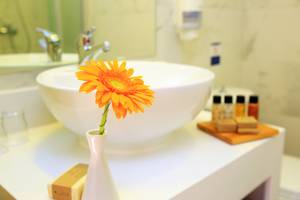 Badezimmer im LABRANDA Marine Aquapark Hotel mit einer Blume im weißen Vasen