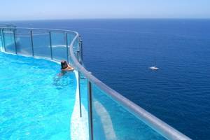 Person in einer Infinity-Pool mit Blick auf den Ozean, im Gloria Palace Amadores Thalasso & Hotel
