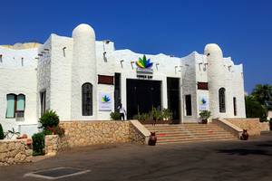 Eingang des Sharm Club Beach Resorts mit einer Person und Pflanzen davor