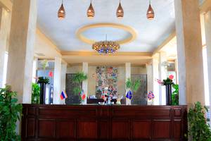 Empfangshalle des Sharm Club Beach Resorts mit hohen Säulen, Kronleuchter und Flaggen.