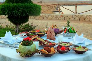 Essen auf einem Tisch im Freien mit Blick auf das Meer im Sharm Club Beach Resort