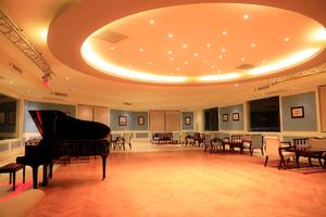 Piano-Lounge im Sharm Club Beach Resort mit einem schwarzen Klavier und gemütlichen Sitzgelegenheiten.