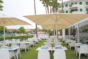 Außenterrasse des LABRANDA Playa Bonita Hotels mit großen Sonnenschirmen und weißen Tischen und Stühlen.