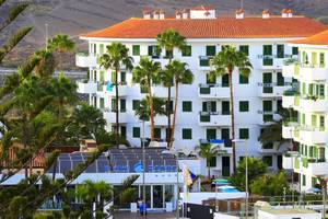 Außenansicht des LABRANDA Playa Bonita Hotels mit weißen Gebäuden, roten Dächern und grünen Fensterläden.