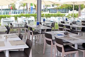 Restaurant im Freien des LABRANDA Playa Bonita Hotels mit weißen Tischen und Stühlen unter großen Schirmen.