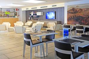 Innenansicht des LABRANDA Playa Bonita Hotels mit weiß gestrichenen Stühlen und Tischen im Restaurant.