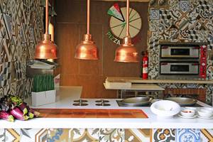 Innenansicht der Pizzaherstellung im LABRANDA Playa Bonita Hotel mit Küchenutensilien und dekorativen Elementen.