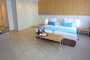 Zimmer im Labranda Playa Bonita Hotel mit zwei Betten, Tisch, Sofa und Dekor.