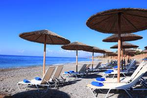 Strand des Labranda Kiotari Miraluna Resorts mit Sonnenschirmen und Liegestühlen