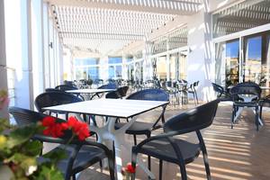 Restaurantterrasse des LABRANDA Kiotari Miraluna Resorts mit Tischen und Stühlen unter einem Pergoladach.