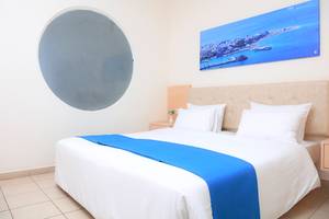 Ein geräumiges Hotelzimmer im LABRANDA Kiotari Miraluna Resort mit einem Doppelbett, einer Stadtansicht und einem runden Spiegel.