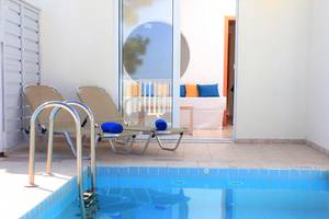 Zwei Liegen mit blauen Handtüchern neben einem Pool im LABRANDA Kiotari Miraluna Resort.