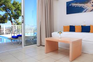 Innenansicht eines Zimmers im LABRANDA Kiotari Miraluna Resort Hotel mit Blick auf den Balkon und den Pool.