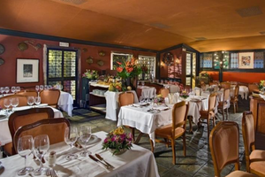 Innenansicht des Restaurants im Montecarlo Hotel mit gedeckten Tischen und Stühlen.
