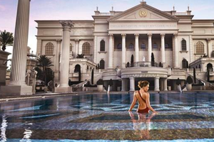 Eine Frau steht in einem runden Pool vor dem Caesars Palace Hotel.