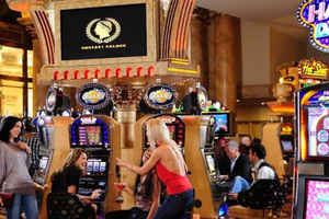 Mehrere Frauen spielen an Spielautomaten in Caesars Palace, mit dem Hotelnamen im Hintergrund.
