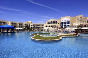 Außenpool des Wyndham Garden Salalah Mirbat Hotels mit blauem Dach und vielen Sonnenliegen