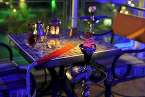 Tisch mit Wasserpfeife bei Nacht im Wyndham Garden Salalah Mirbat Hotel.