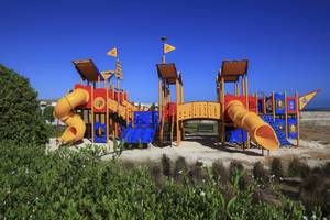 Kinderspielplatz im Wyndham Garden Salalah Mirbat Hotel mit gelben und blauen Rutschen.