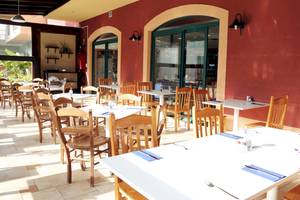 Innenbereich des Restaurants im BLUESEA Aloe Corralejo Hotel mit roten Wänden und grünen Fenstern.