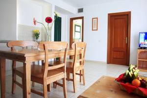 Wohnzimmer des Bluesea Aloe Corralejo Hotels mit Tisch, Stühlen und Fernseher.