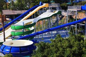 Wasserrutschen im Blue Bay Beach Resort mit grünen, gelben und blauen Bahnen.