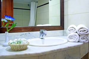 Badezimmer im Blue Bay Beach Resort mit Waschbecken, Spiegel und Handtüchern.