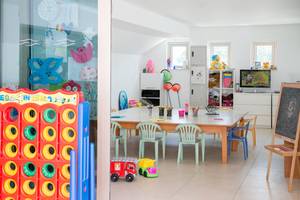 Kinderzimmer im Asterias Beach Hotel mit bunten Spielzeugen und Möbeln.
