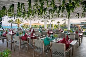 Ein üppig dekoriertes Terrassenrestaurant des Asterias Beach Hotels mit Blick auf das Meer.