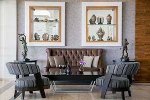 Lobby-Lounge des Asterias Beach Hotels mit Möbeln, Vasen und Statuen.
