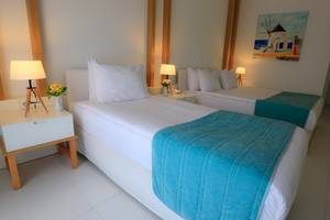 Doppelzimmer im LABRANDA TMT Bodrum mit zwei Betten, weißer Bettwäsche und blauen Decken.