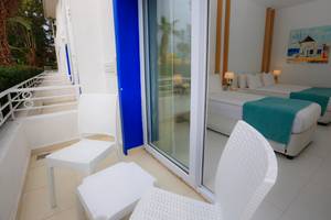 Ein Balkon mit zwei Betten und einem kleinen Tisch im LABRANDA TMT Bodrum Hotel.